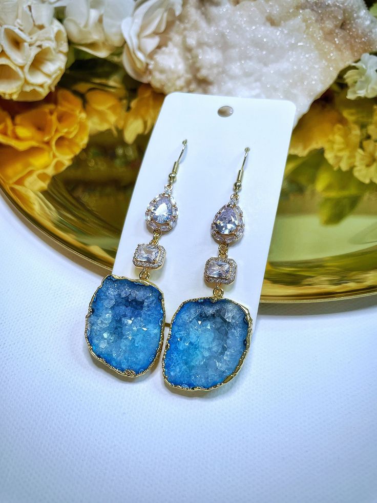 Beautiful one of a kind geode earrings. ♡ These dangle earrings will make a statement wherever you go! 24k Gold Plated Geodes & Champagne Gold Crystal Charms. All natural crystals contain some inclusions, cracks, scratches, chips and discolorations. There can be variations of size, weight, shape and color. Please review the photos for details or reach out if you have any questions! ❀ Due to these including geodes please keep in mind that they may have a slight weight to them, each pair may vary in weight. Care Instructions: - Please avoid contact with any chemicals such as oil, lotion, perfume, etc.   - If needed wipe gently with warm water with a soft cloth. Do not use any cleaning products containing chemicals or antibiotic soaps. - Use a soft jewelry polishing cloth to restore shine and Soft Jewelry, Geode Earrings, Druzy Earrings, Agate Earrings, Earrings Crystal, Earrings Wedding, Gold Crystal, Crystal Charm, Earrings Boho