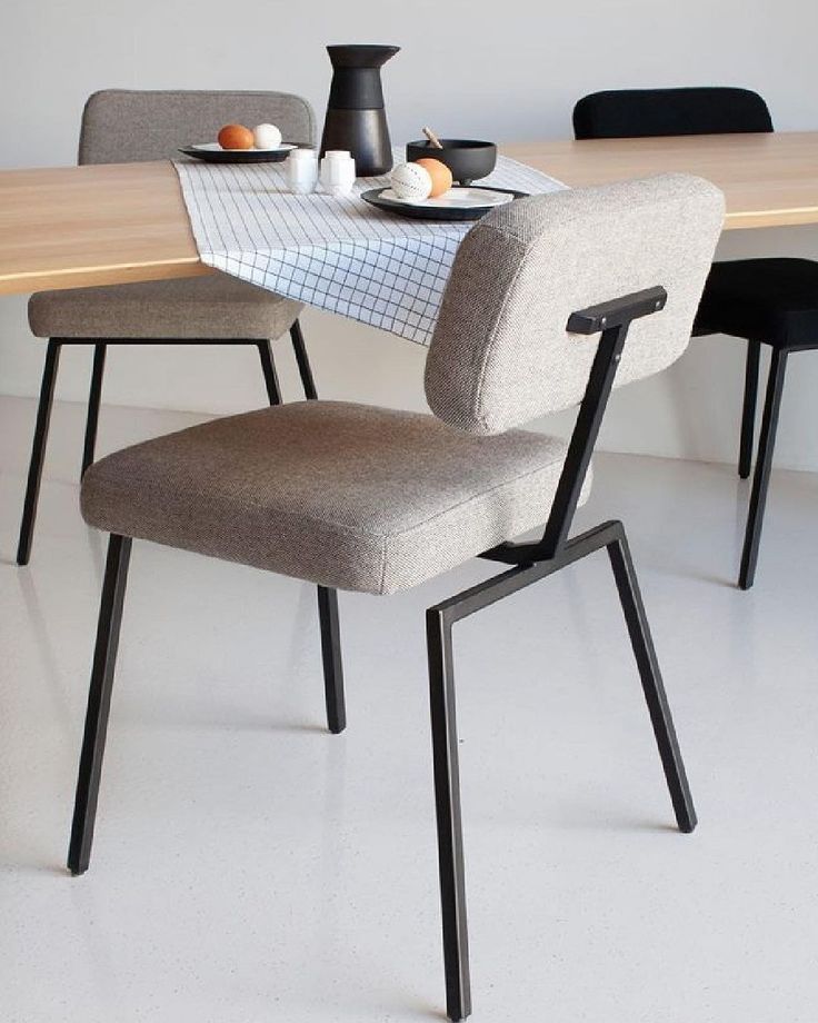 a dining table with two chairs and plates on it