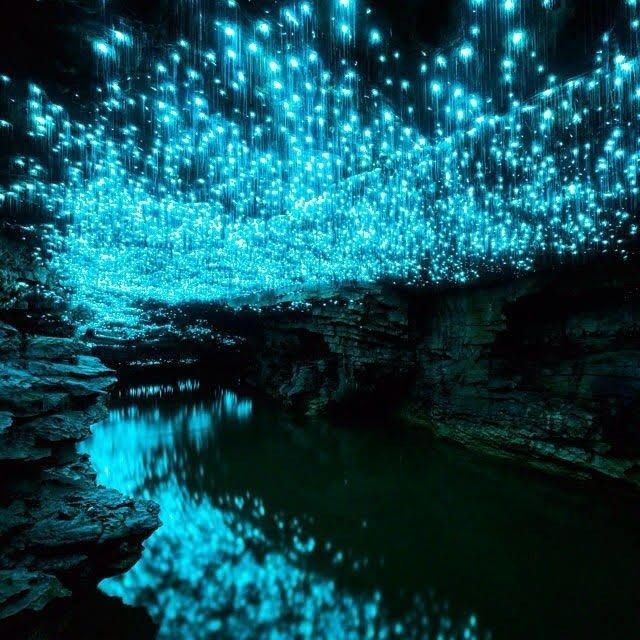 the lights are hanging from the ceiling in the cave, and reflecting on the water