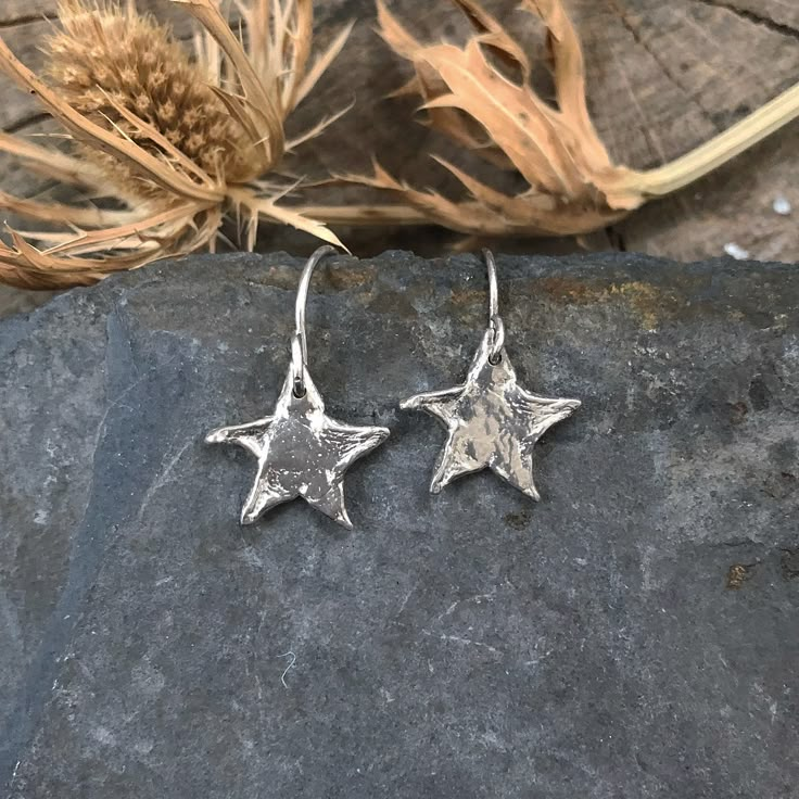 Star charms dangle from handmade ear wires. Available in sterling silver or brass with gold-filled earring wires. Length 1/2" Width 1/2" Our crescent moon, star, full moon and ellipse earrings are available in brass and sterling silver. This piece is handmade-to-order, please allow 1 - 2 weeks to ship unless this piece is in stock. All metal is nickel free. The Moon Is Silver I Like Silver, Fun Silver Earrings, Handmade Metal Earrings, Metal Earrings Handmade, Earrings Handmade Silver, Handmade Silver Earrings, Star Celestial, Silver Star Earrings, Celestial Earrings