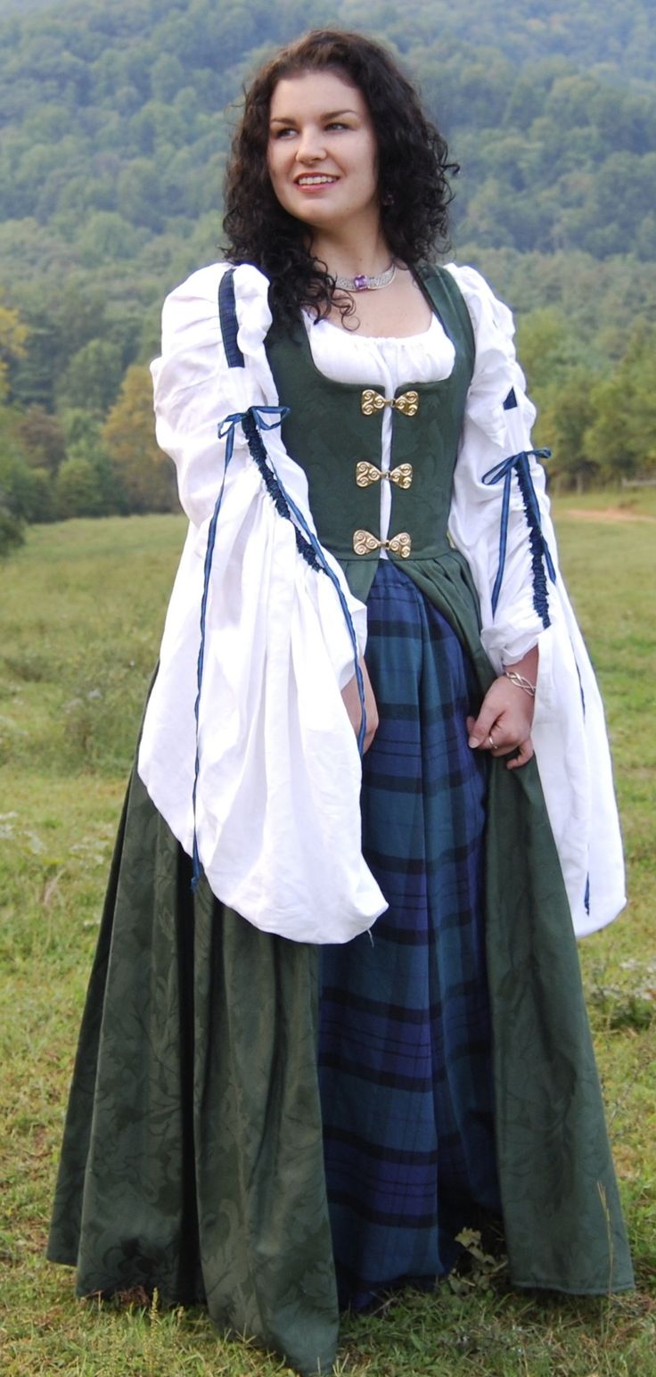 My hearts in the Highlands wherever I go!   This is the perfect dress for an Irish or a Scottish lass . It was a popular style in the mid 1500s. The Irish overdress has spring steel boning in front for support. It has bronze clasps and is in a cotton brocade. It is shown with a traditional leine, that's the chemise with the big sleeves; and a tartan underskirt. It is available in stock in hunter green with celtic knot clasp. Do not professionally dry clean! The high heat of dry cleaning will mel Irish Folk Dress, Scotland Traditional Dress, Ireland Traditional Dress, Scottish Traditional Clothing Women Highland, Irish Clothes Traditional, Irish Dress Traditional, Irish Clothing Women, Scottish Traditional Clothing, Irish Traditional Clothing