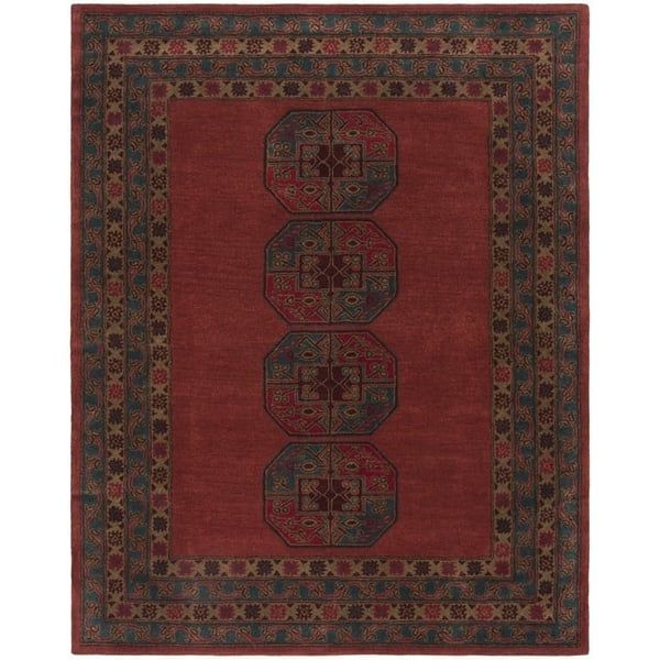 a red rug with an intricate design on the bottom and sides, in different colors