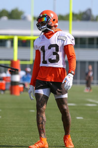 a football player wearing an orange and white uniform on the field