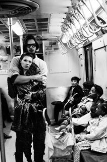 black and white photograph of people on subway train with one person holding the other's arm