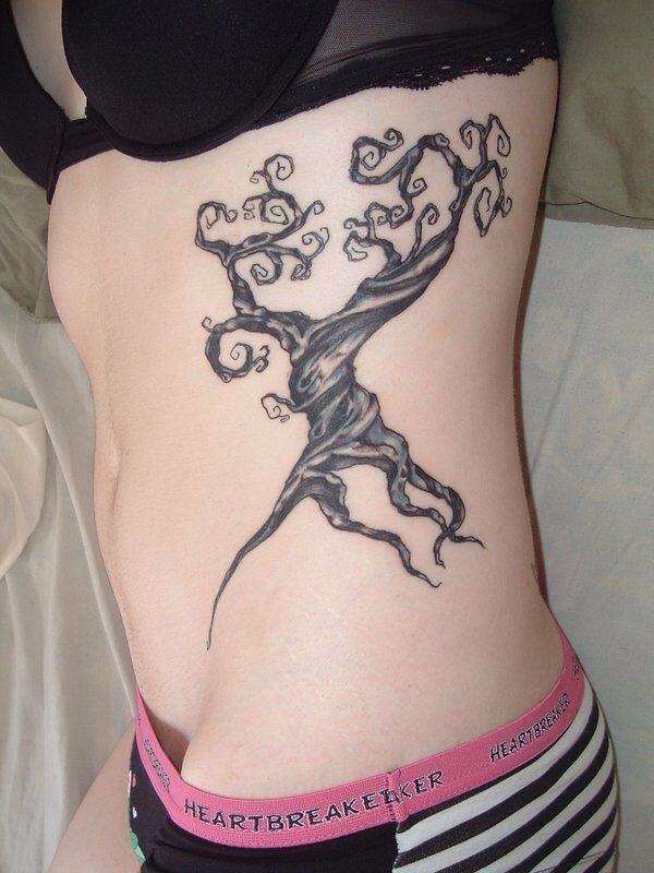 a woman's stomach with a tree tattoo on it