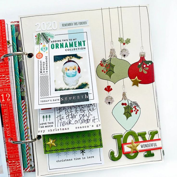 a scrapbook with christmas ornaments and other holiday decorations on it's cover, next to a ruler