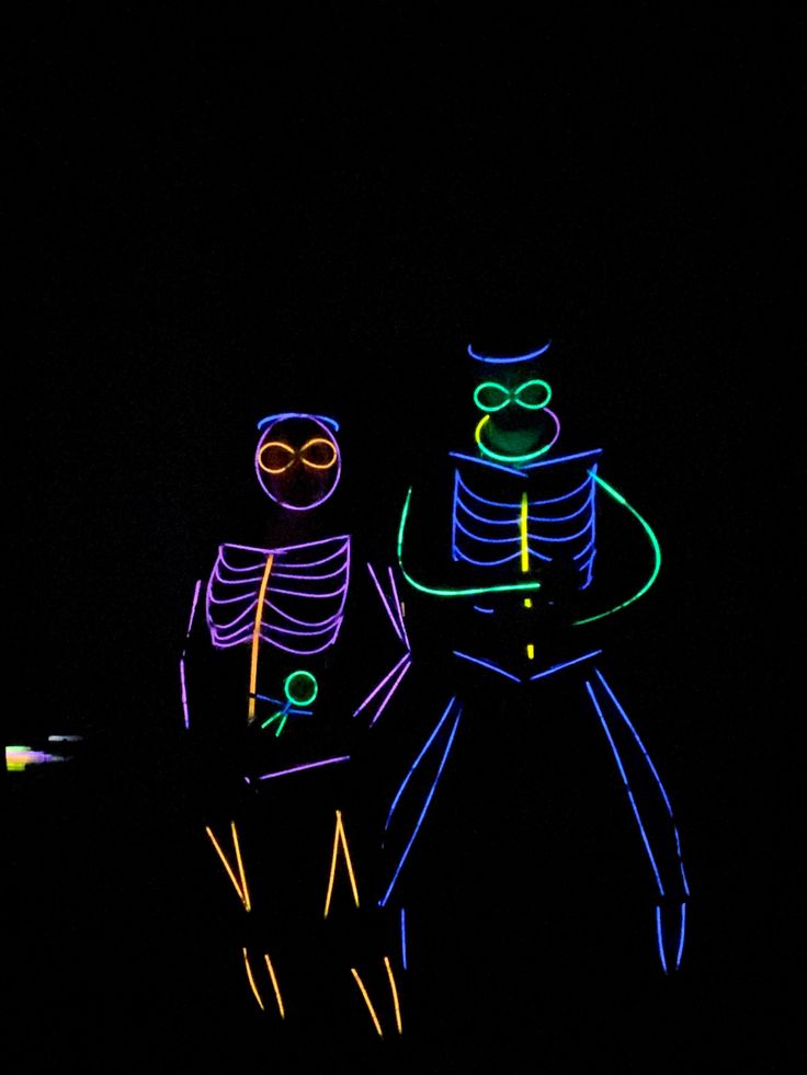 two people are standing in the dark with their arms around each other