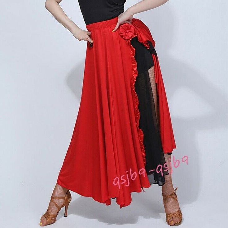 a woman in a red and black dress posing with her hands on her hips,