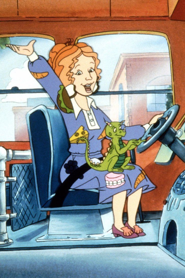 a woman sitting in the driver's seat of a bus with an alligator on her lap