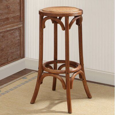 a wooden bar stool sitting on top of a rug next to a dresser and window