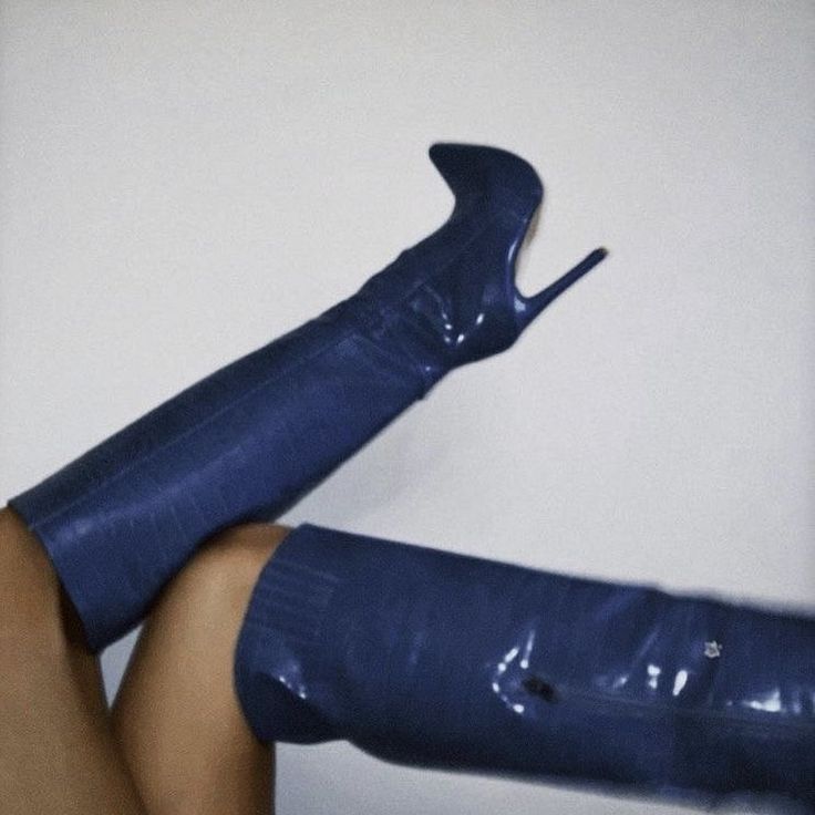 a woman's legs in high heeled boots with blue plastic covering them and the bottom part of her leg