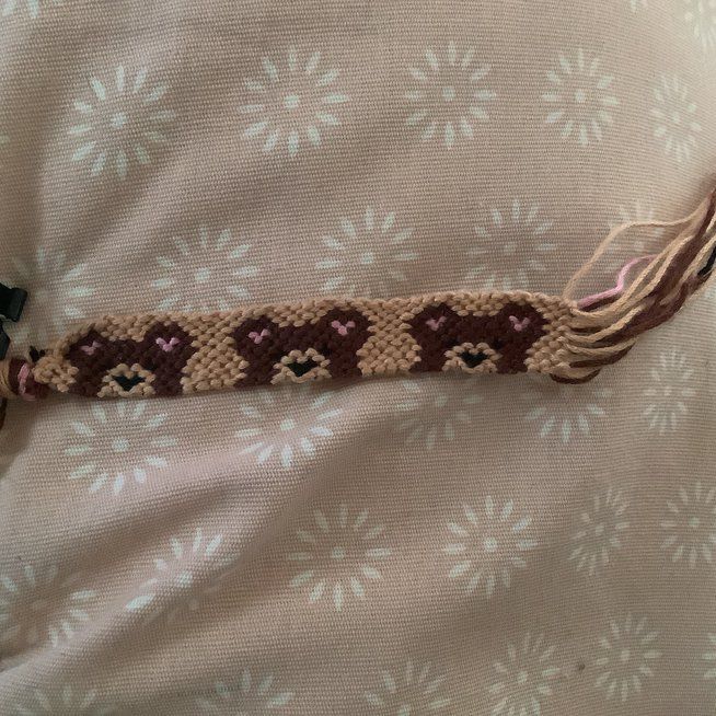 a brown and white bracelet with hearts on it