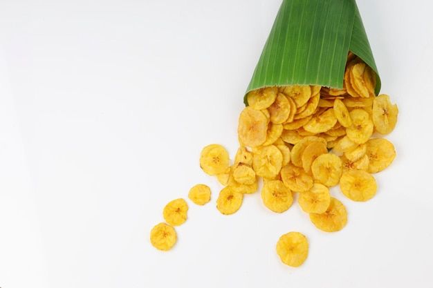 a pile of banana slices sitting on top of a green leafy plantain cone