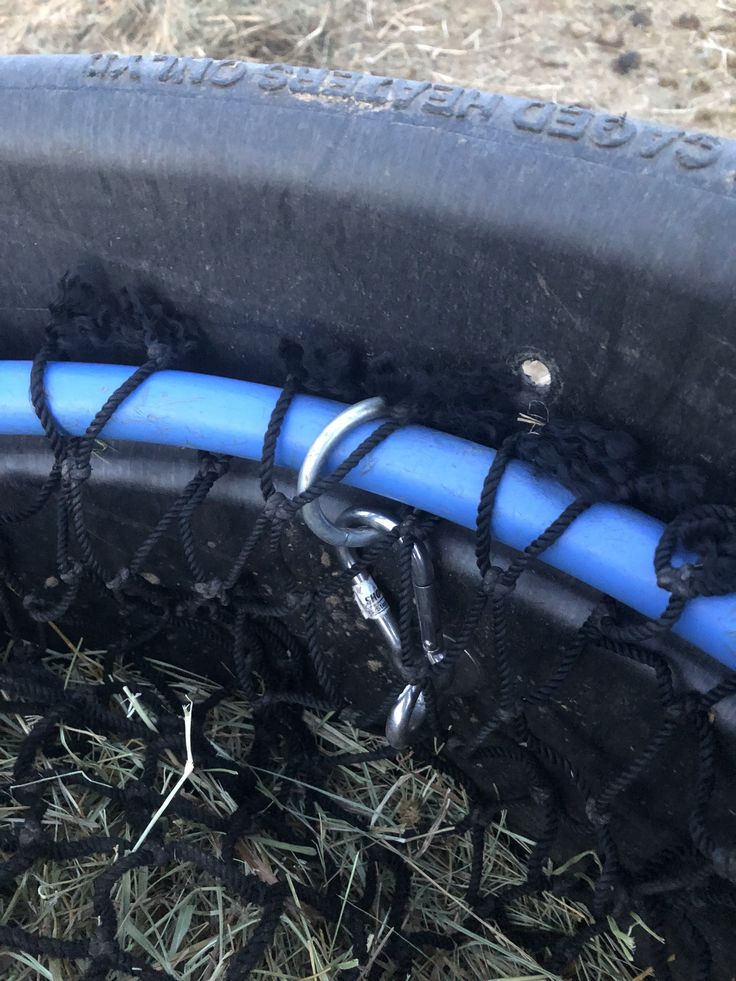 a tire with some black and blue rims on the ground next to dry grass