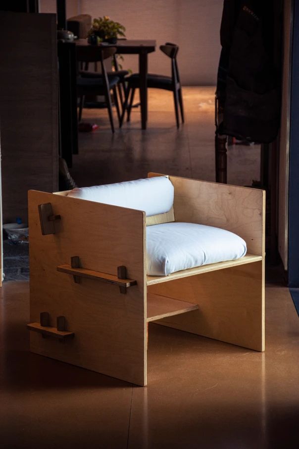 a chair that is made out of plywood and has a cushion on the seat