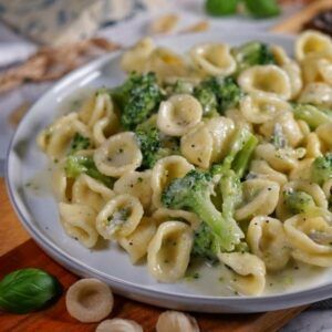 a white plate topped with pasta and broccoli