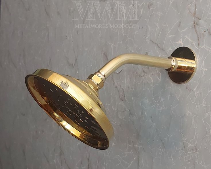 a gold shower head on a white marble wall with the words, we are not sure what this is