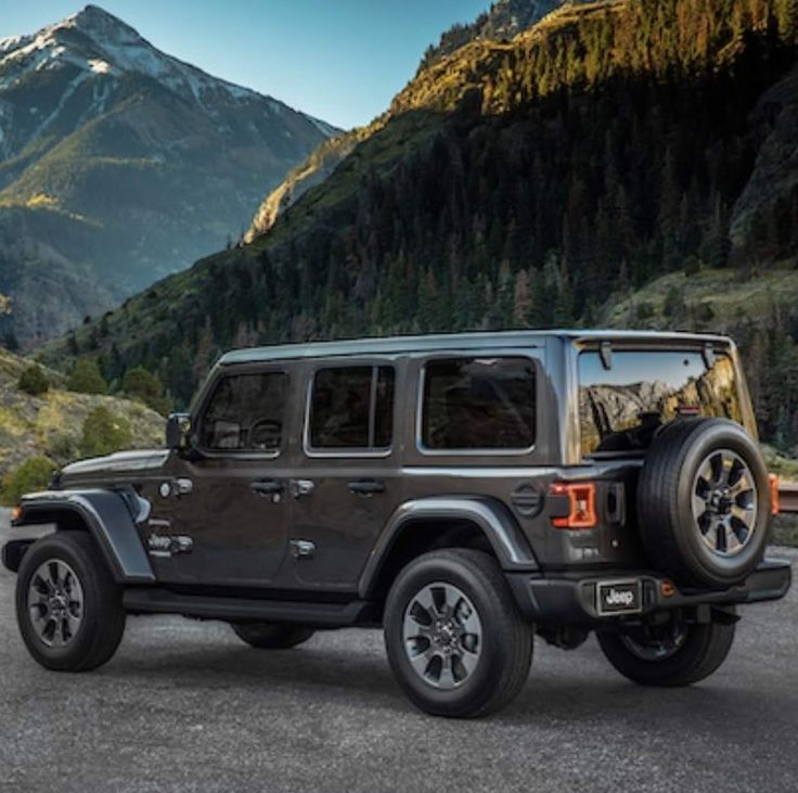 a black jeep parked in front of mountains