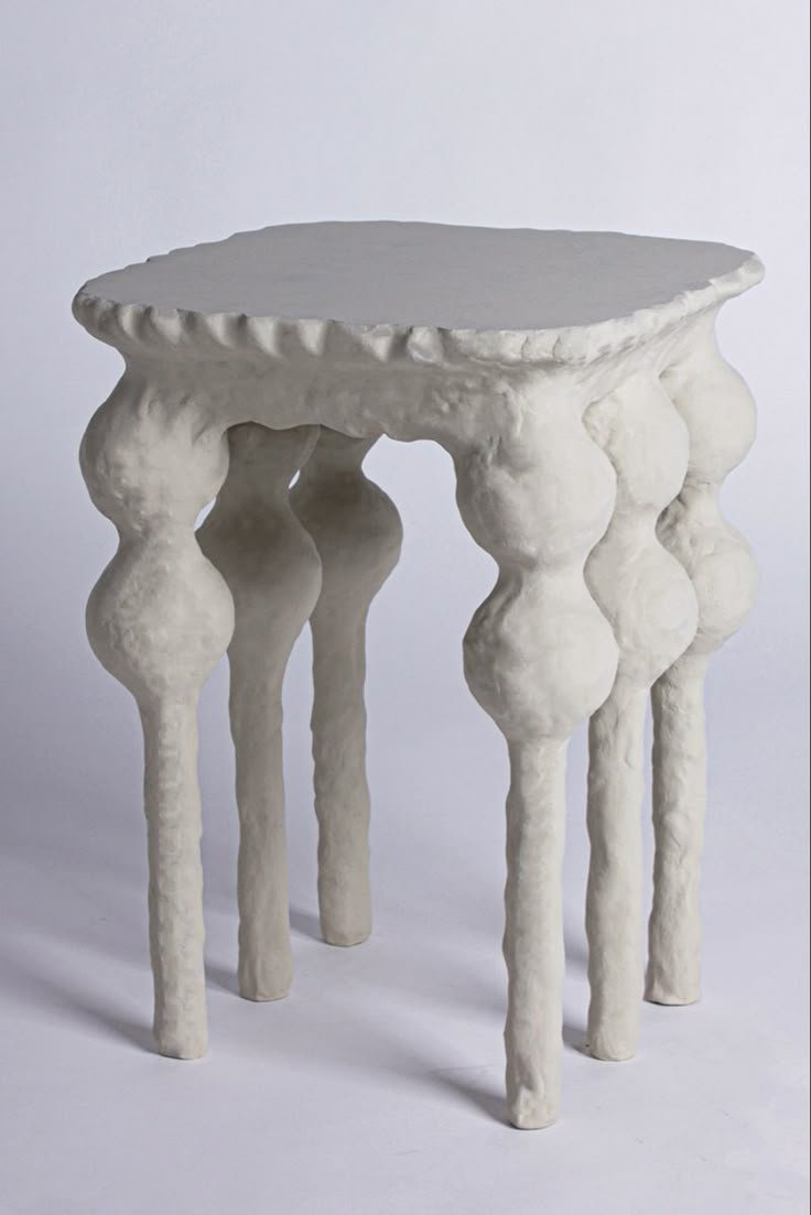 a small white table with three legs on it