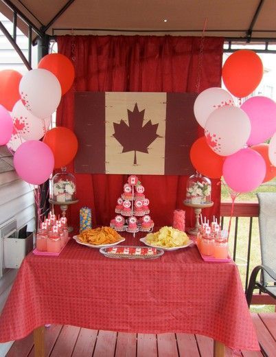 a table topped with lots of food and balloons