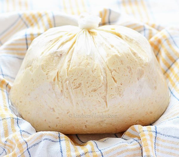 a bag of bread sitting on top of a blue and white checkered blanket