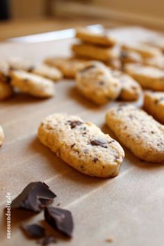 cookies and chocolate chips are laying on the baking sheet, ready to be baked in the oven