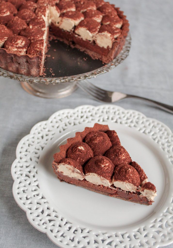 a piece of pie on a plate next to a cake server with a slice missing