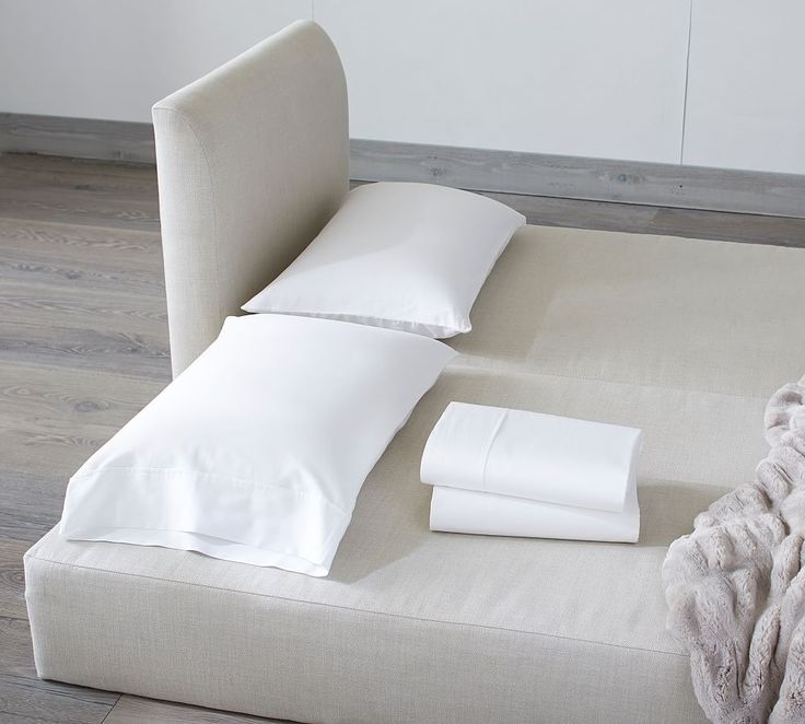 a bed with white sheets and pillows on top of it next to a pillow case