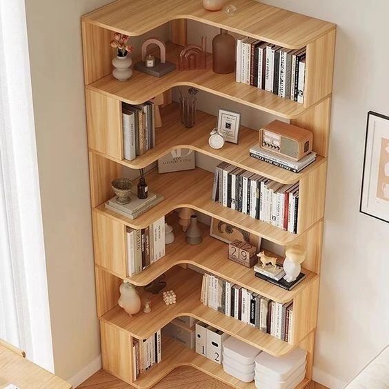 a wooden book shelf filled with books next to a white wall in a living room