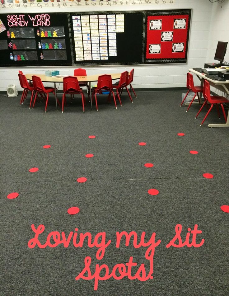 an empty classroom with red chairs and polka dots on the floor that says loving my sit spots