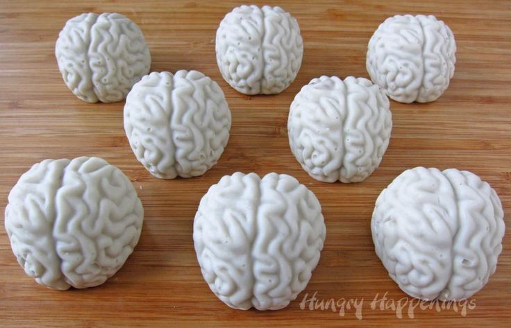 six white brain shaped cookies on a wooden table