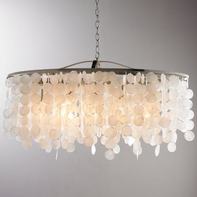 a chandelier made out of shells hanging from a ceiling fixture in a room