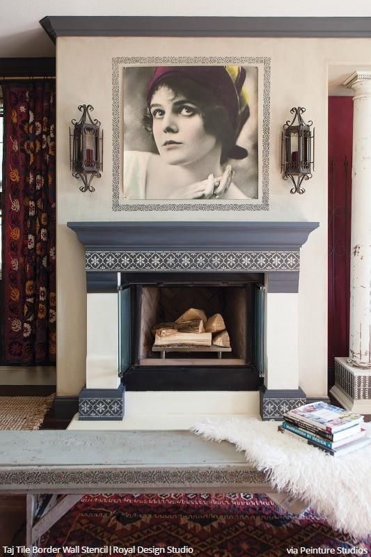 a fireplace in a living room with a painting on the wall above it and a rug underneath