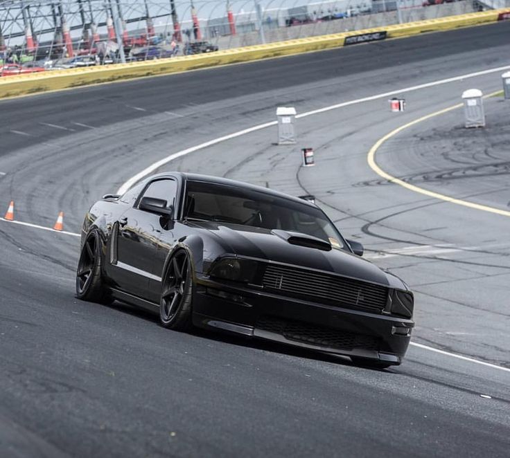 a black car driving down a race track