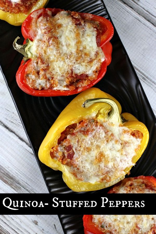 three stuffed peppers on a black plate with the words quinoa - stuffed peppers