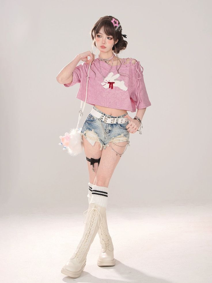 a woman in short shorts and a pink shirt is posing for the camera with her hand on her hip