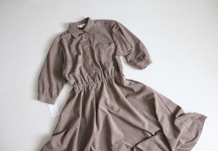 "Vintage 1980's taupe faux/ultra suede swing dress with button front, tab collar, stretch waist, and full flouncy skirt. Fits Like: Medium | No Label Size Circa 1980's Material: cotton-poly blend Condition: excellent Measurements: 38\" bust | 30-34\" waist | full hip | 17\" bodice length | 16\" shoulder | 44\" length" Faux Suede Dress, Suede Dress, Swing Dress, Faux Suede, Dress Clothes For Women, Bodice, Dress Outfits, Womens Dresses, Clothes For Women