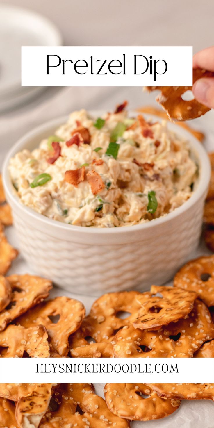 a bowl filled with chicken salad next to crackers on a white plate and the words pretzel dip above it