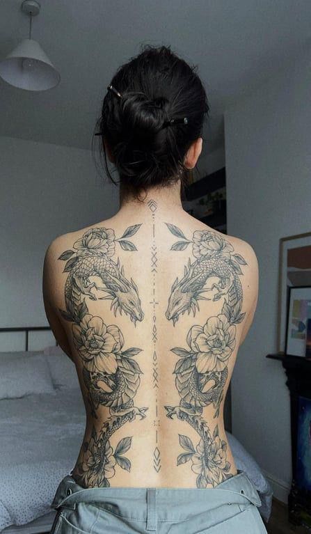 the back of a woman's body with tattoos on her upper and lower back