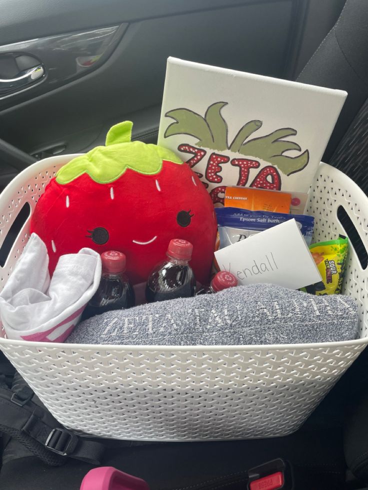 a basket filled with lots of different items in the back seat of a car next to a steering wheel