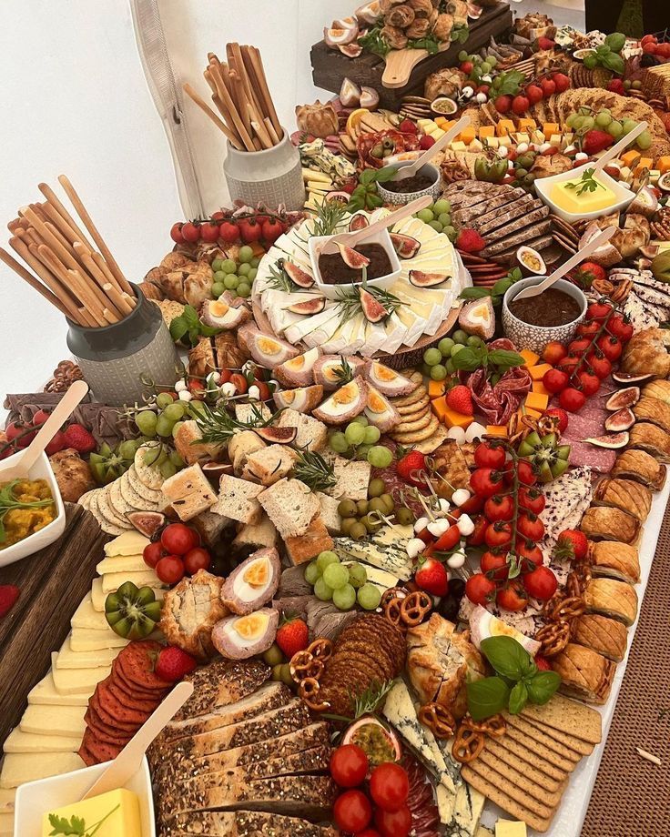 a table filled with lots of different types of cheeses and crackers on top of it