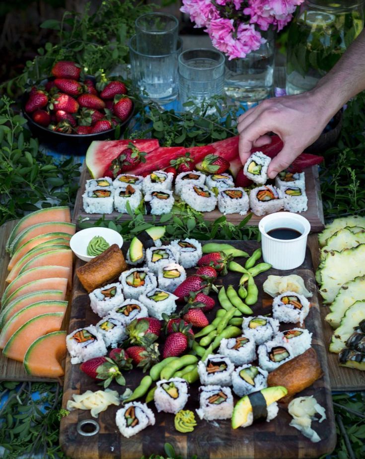 sushi platter with strawberries, cucumbers, and other foods on it