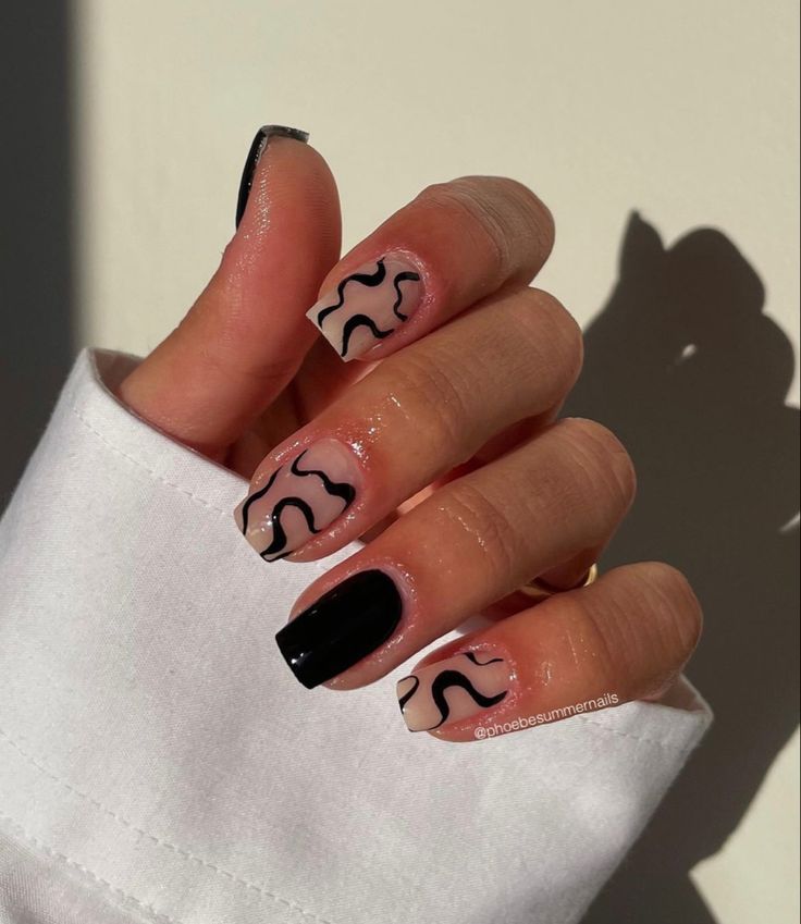 a woman's hand with black and white nail polish