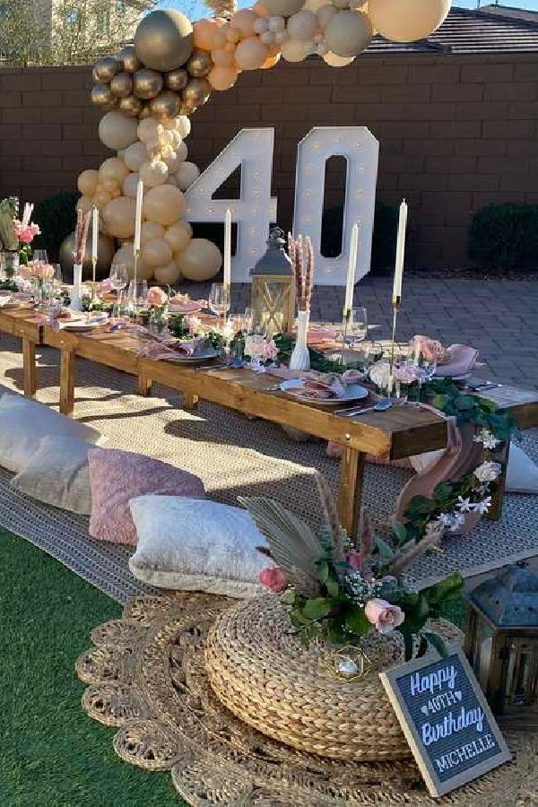 a table set up for a birthday party with balloons and flowers on it, along with candles