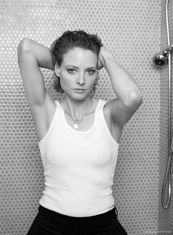 a black and white photo of a woman in the shower with her hands on her head