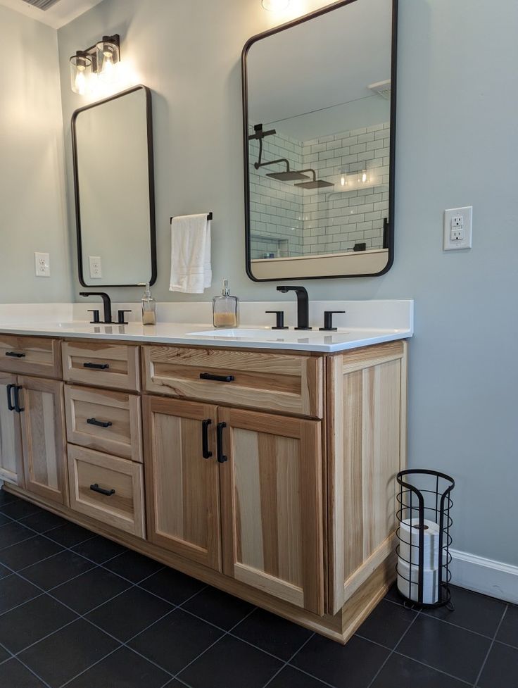 a bathroom with double sinks and two mirrors on the wall next to eachother