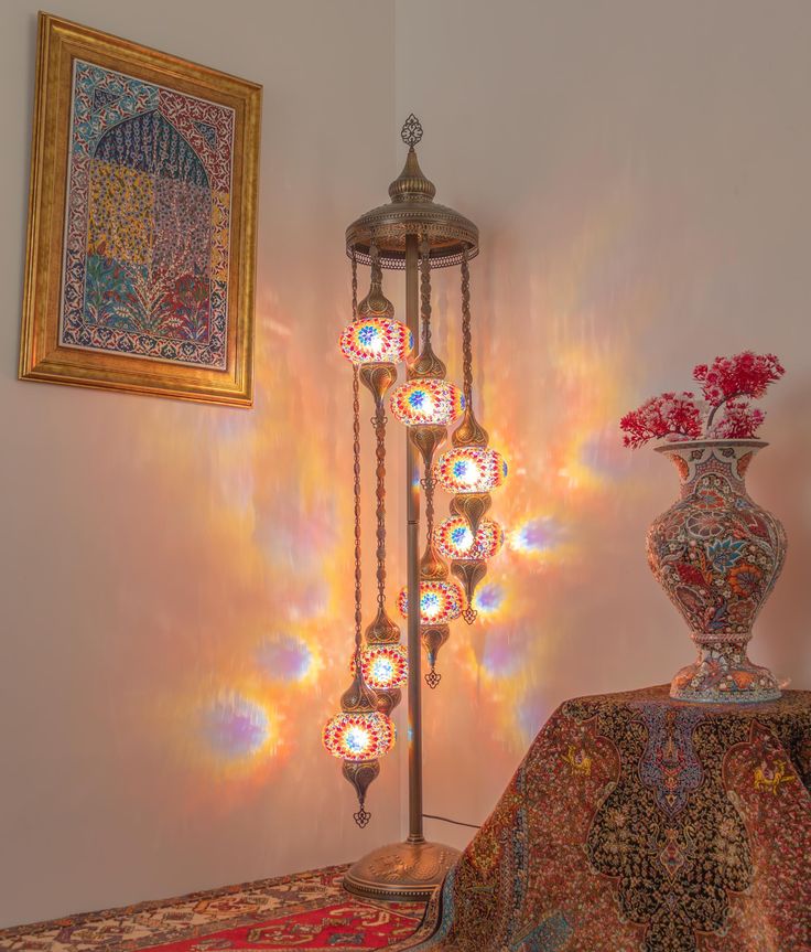 a lamp that is on top of a table next to a vase with flowers in it