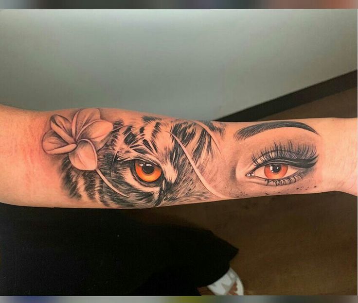 a woman's arm with an orange eye and tiger on it