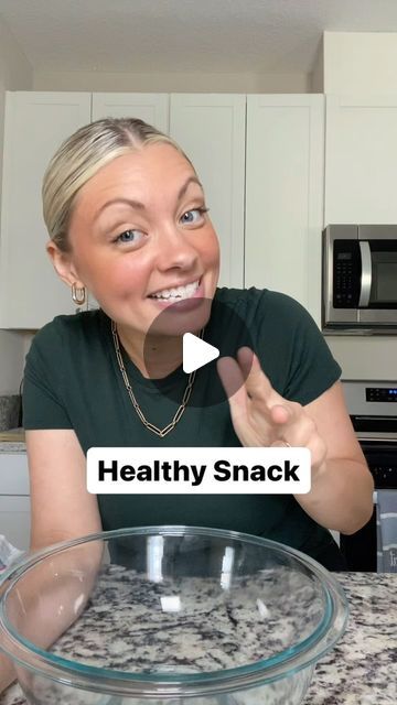 a woman making a funny face in front of a glass bowl with food on it