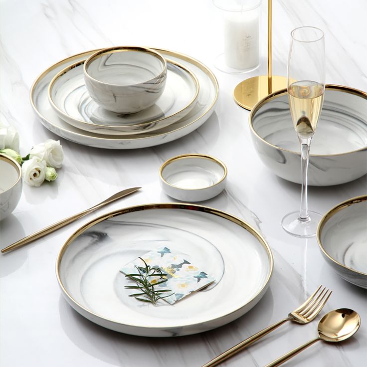 the table is set with gold and white dishes